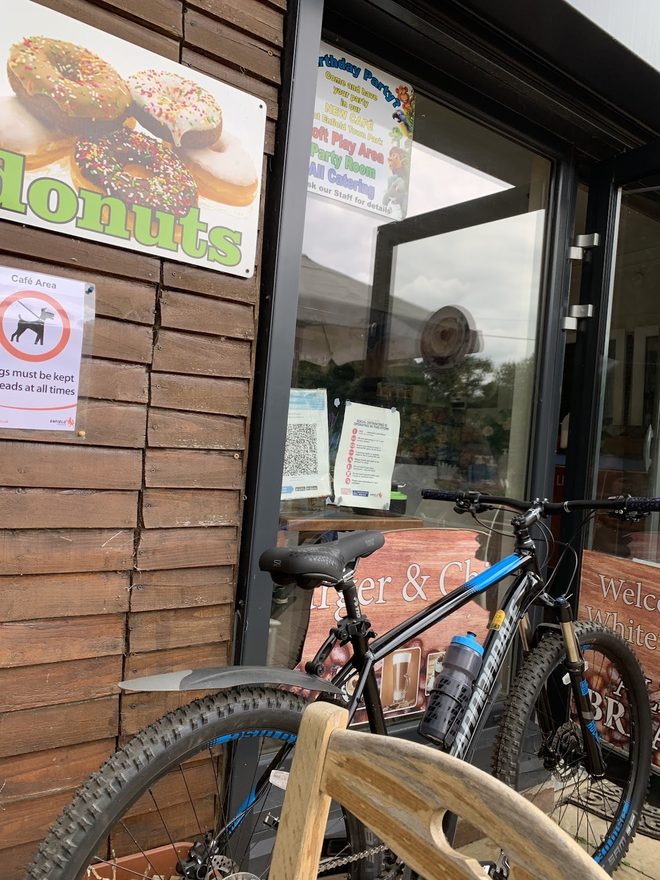 A bike parked against the café wall, cropped to the timber and frame